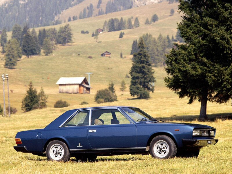 Blue sedan in a mountain field