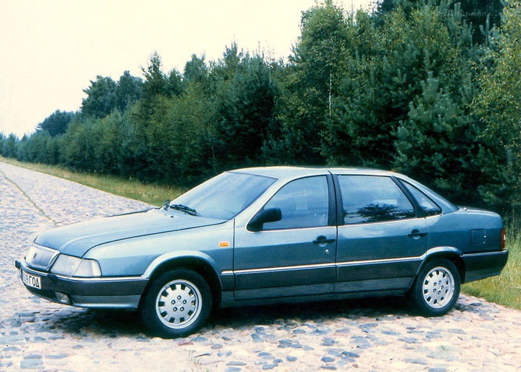 blue sedan on cobblestone road