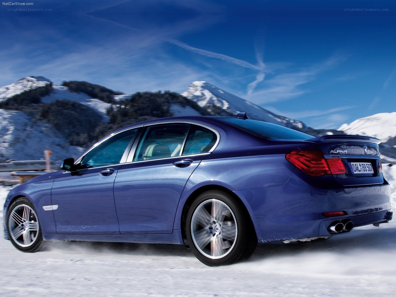 blue sedan on snowy mountain road