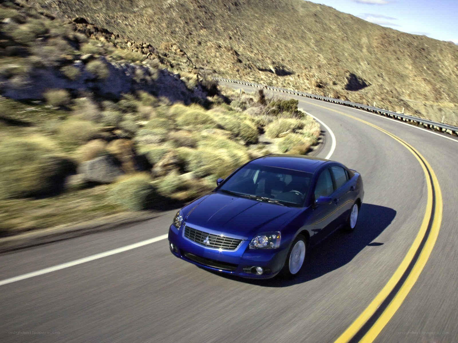 Blue sedan on winding road