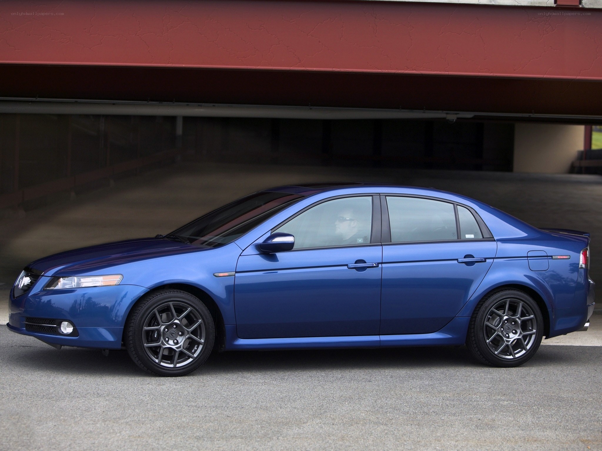 blue sedan parked under overpass