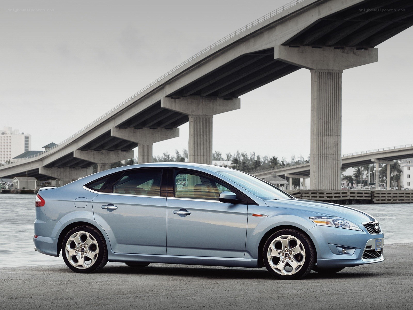blue sedan under a bridge