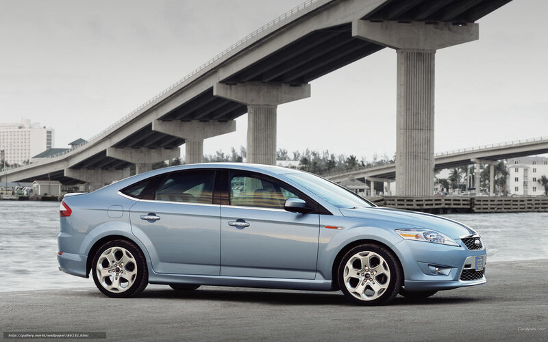 Blue sedan under a bridge