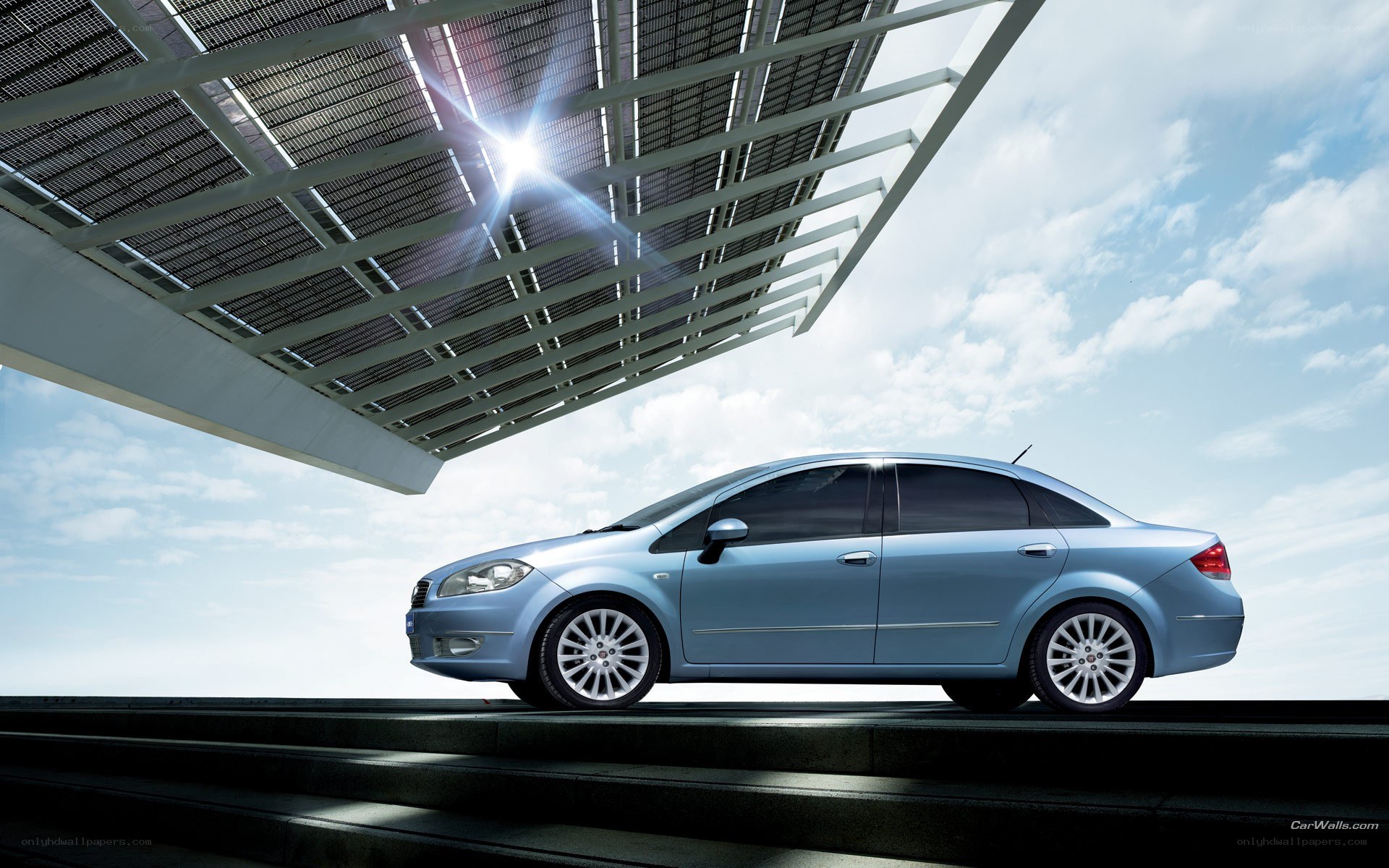 Blue sedan under solar canopy
