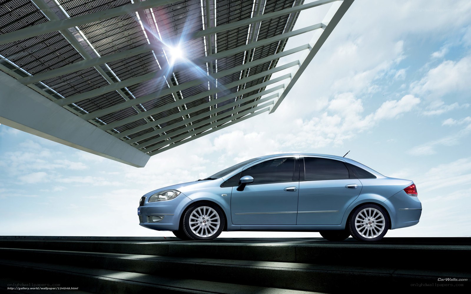 Blue sedan under solar canopy