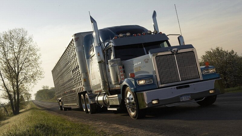 Blue semi-truck on a rural road