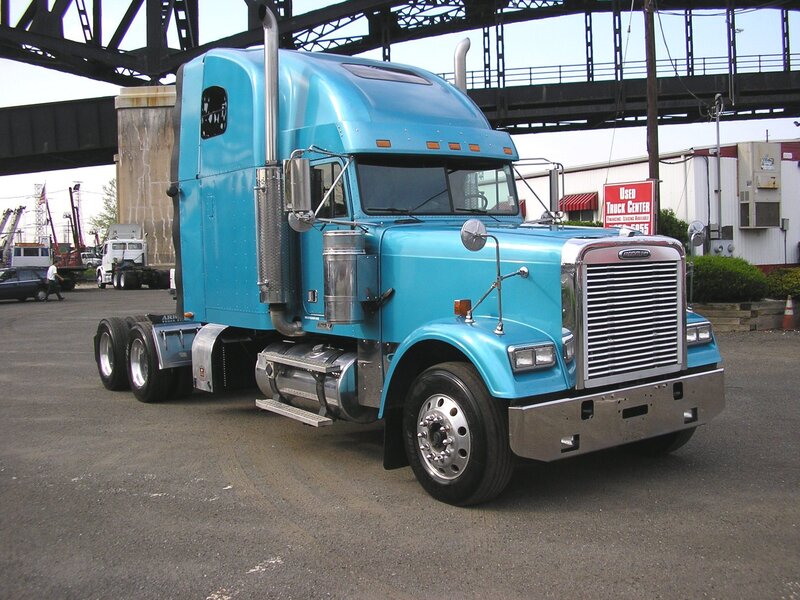 blue semi-truck under bridge