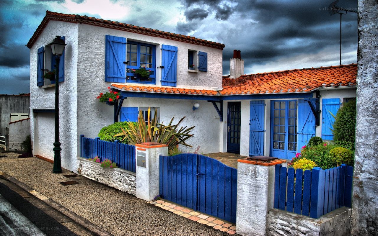 Blue-shuttered house under stormy sky