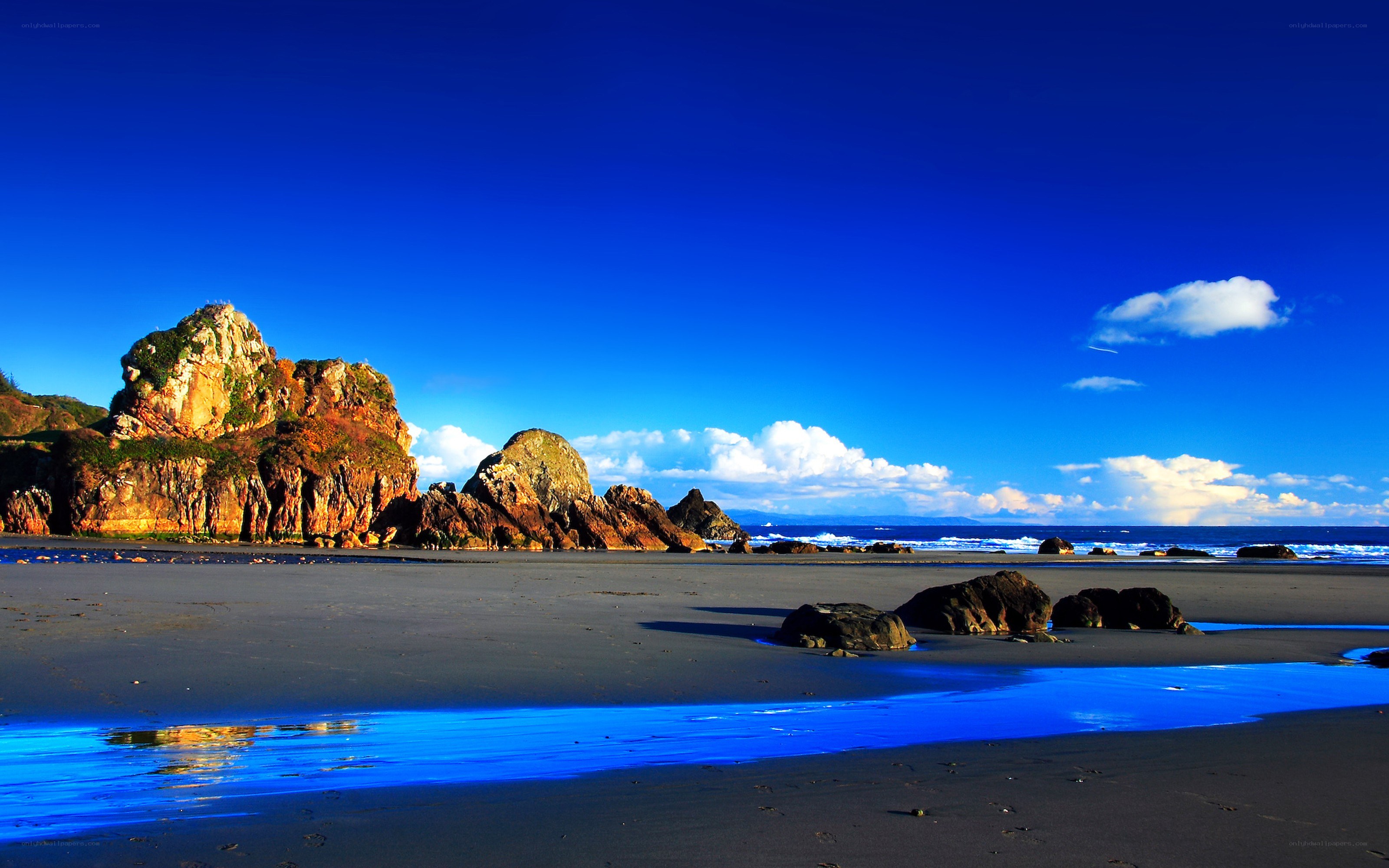 blue sky beach with rocks