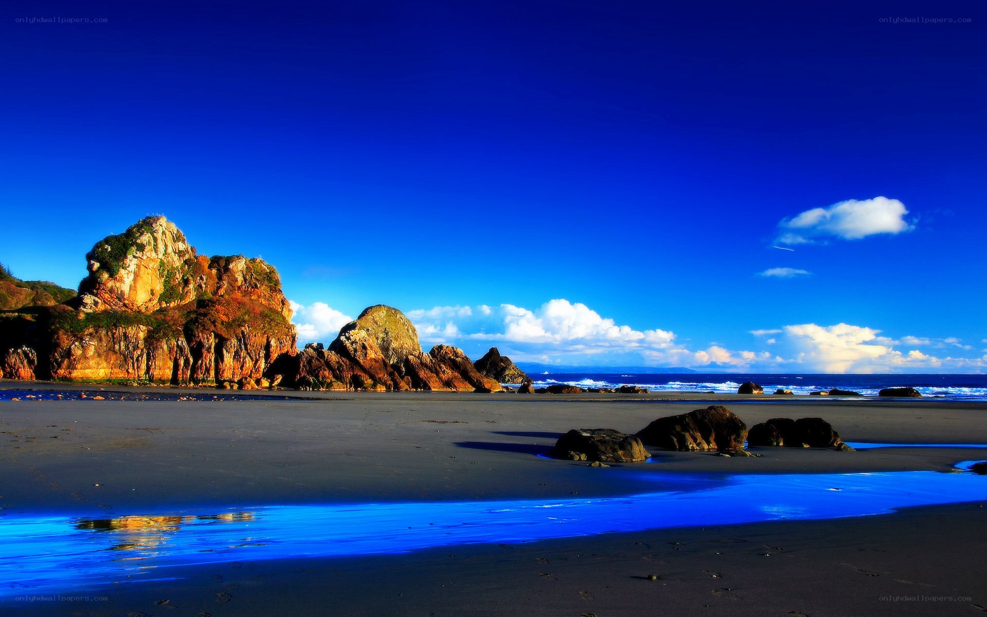 Blue sky beach with rocky cliffs