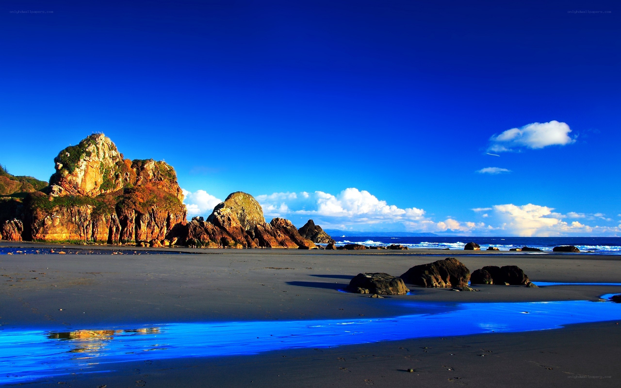 Blue sky beach with rocky cliffs
