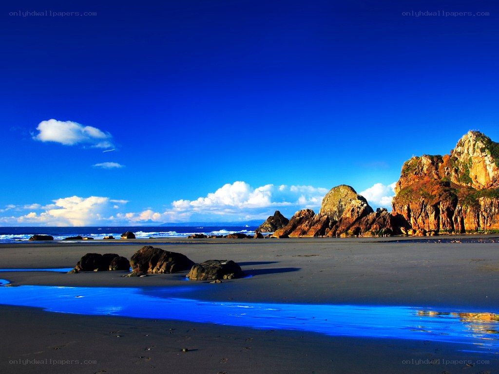 Blue sky beach with rocky cliffs