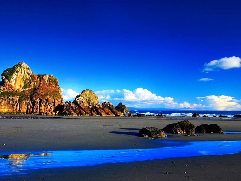 Blue sky beach with rocky cliffs