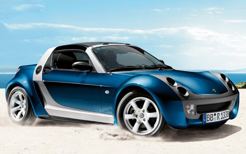 Blue smart roadster on beach
