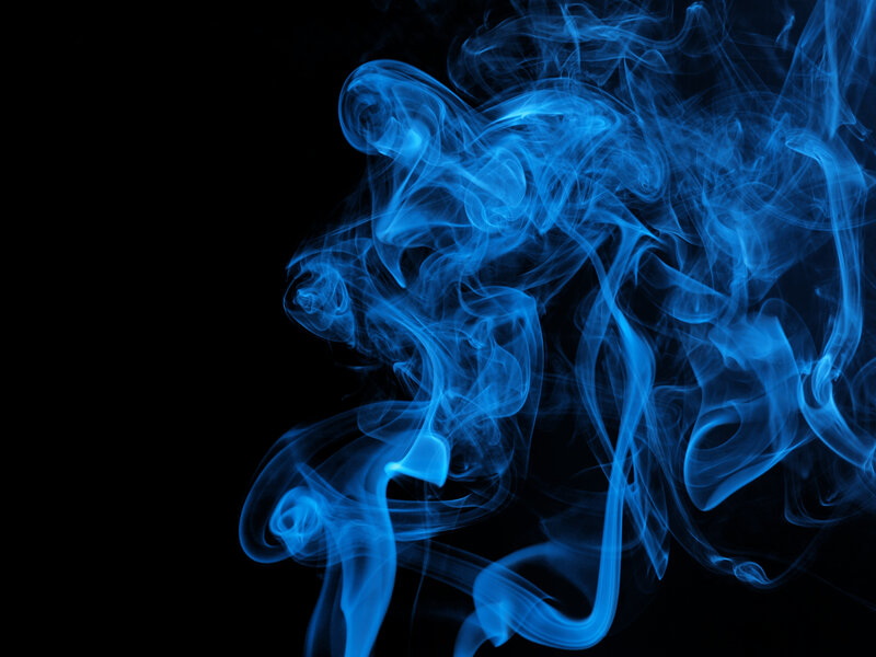 Blue smoke swirls on black