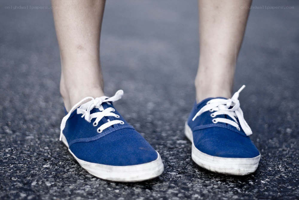 blue sneakers on asphalt