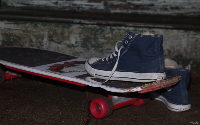Blue Sneakers on Skateboard
