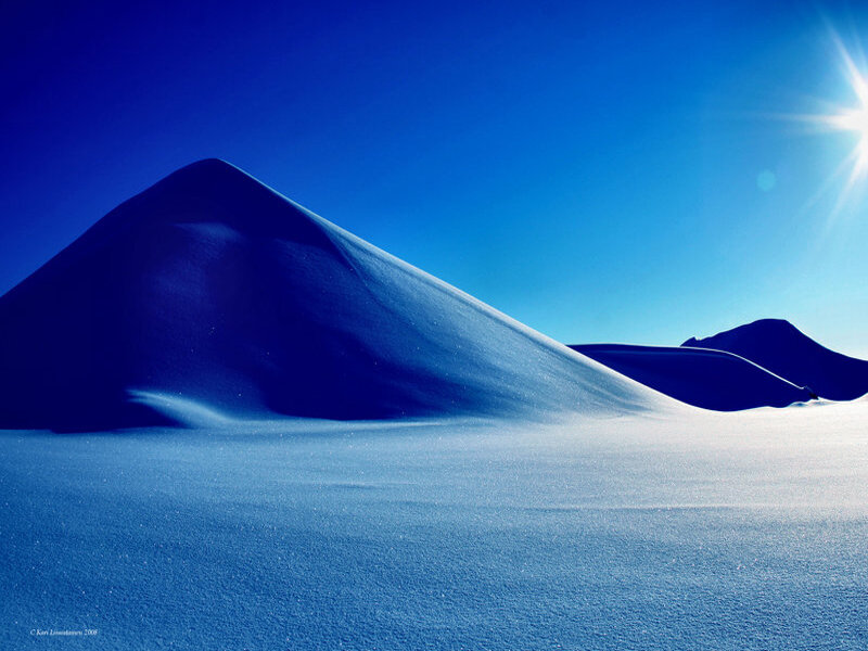 Blue snow dunes under sun
