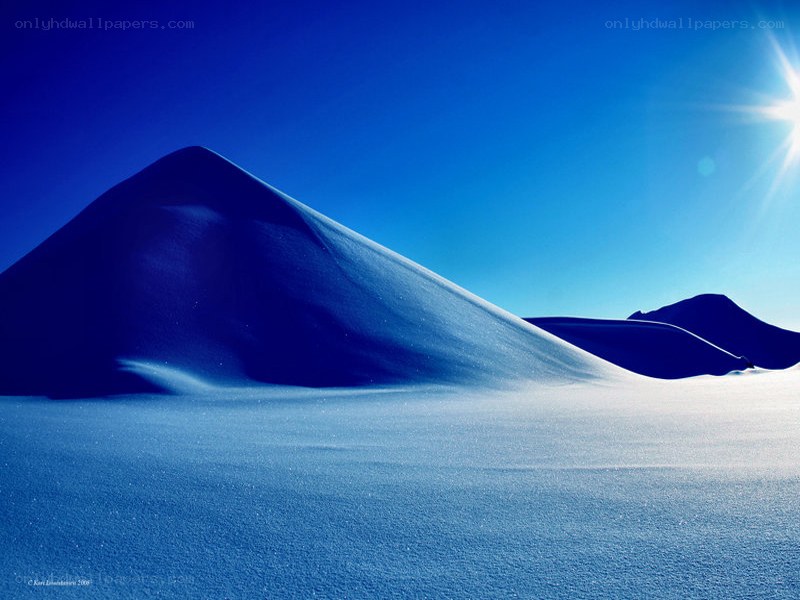 Blue snow dunes under sun