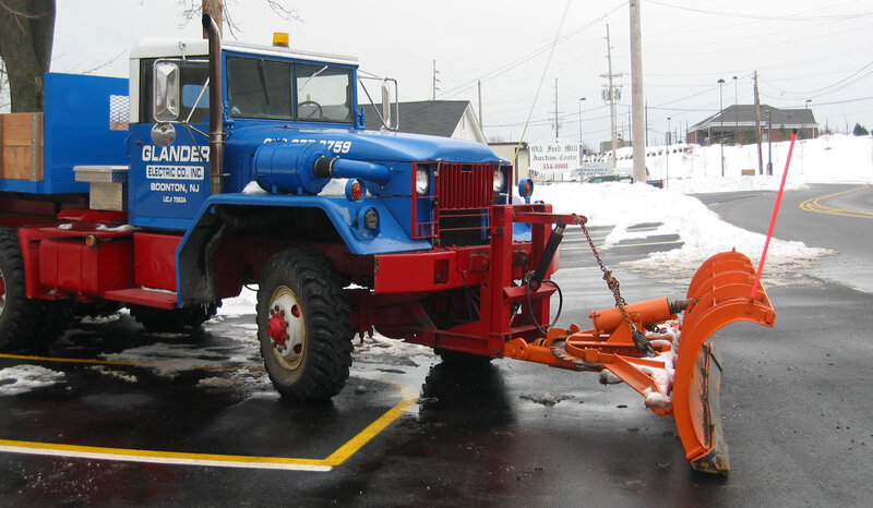 blue snowplow truck in parking lot