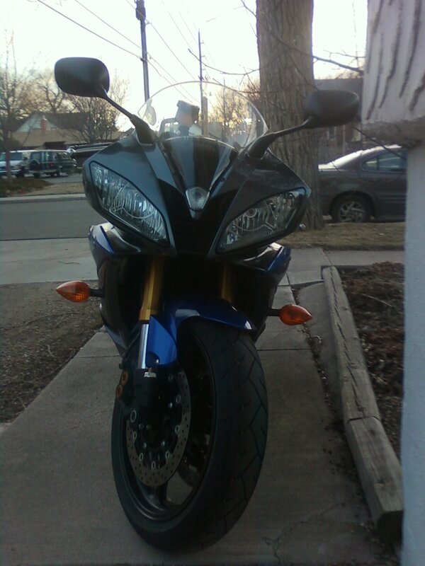 blue sport motorcycle on sidewalk