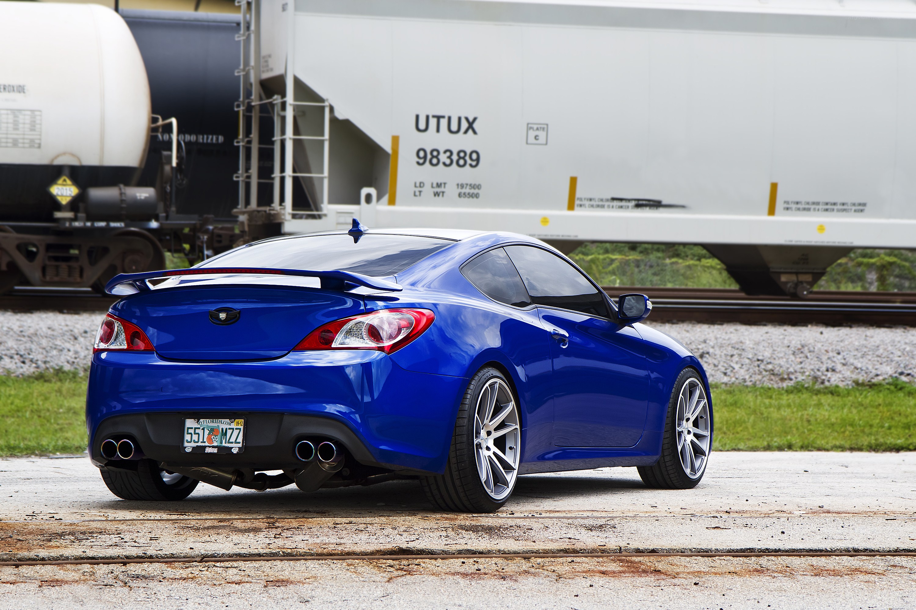 Blue sports car at train crossing
