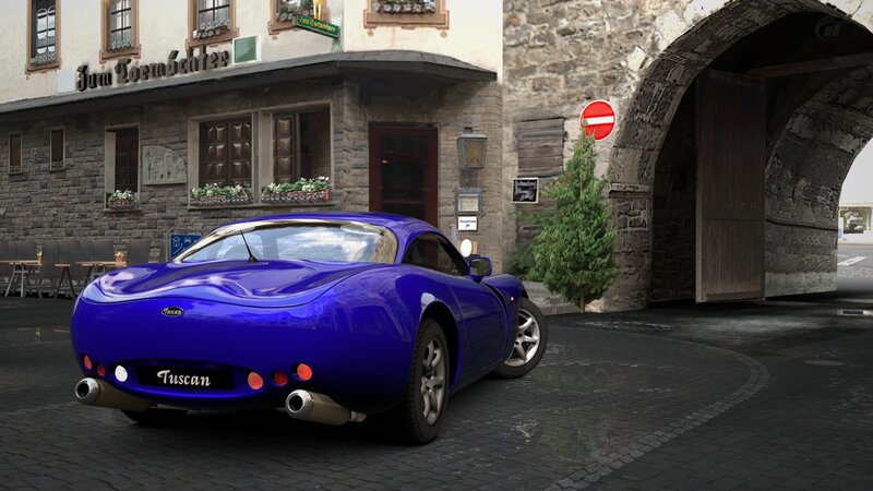 Blue sports car in a town square