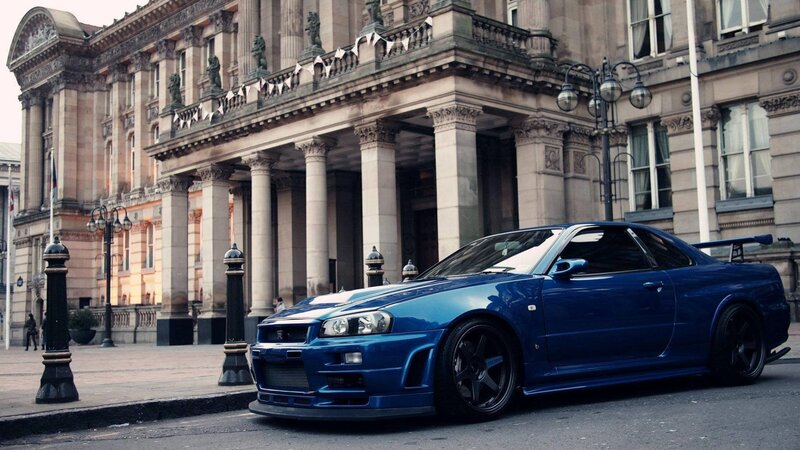 blue sports car in front of building