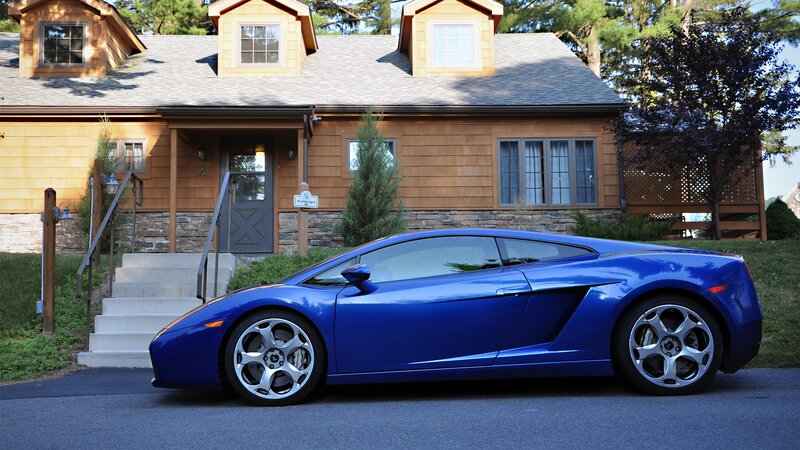 Blue sports car in front of cottage