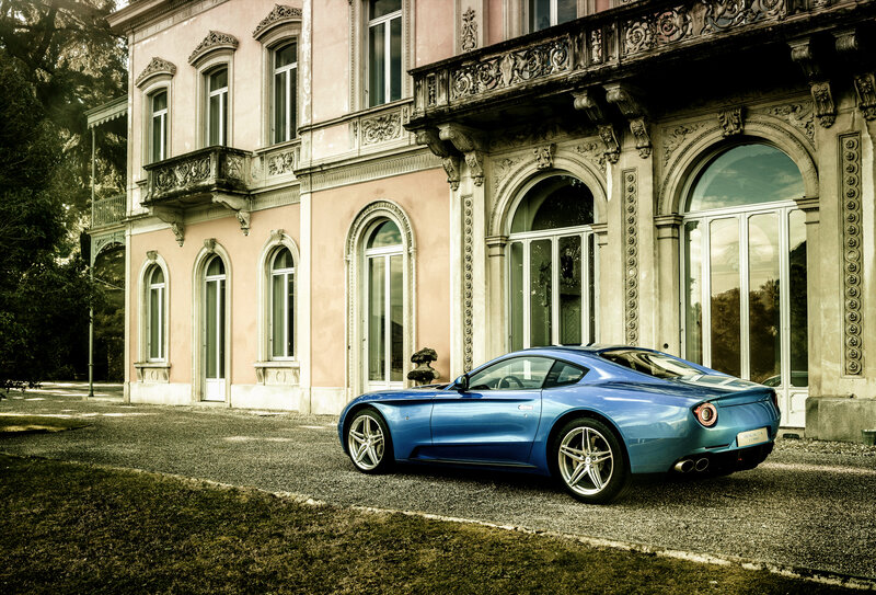 Blue sports car in front of mansion