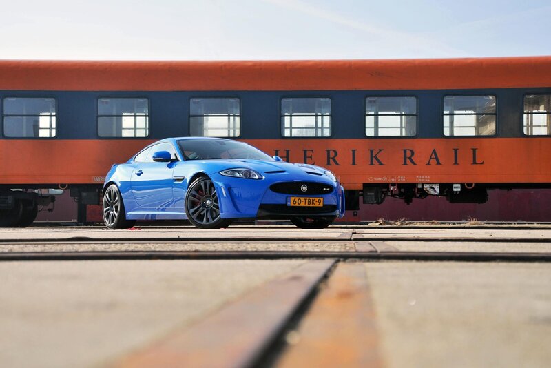 Blue sports car near train