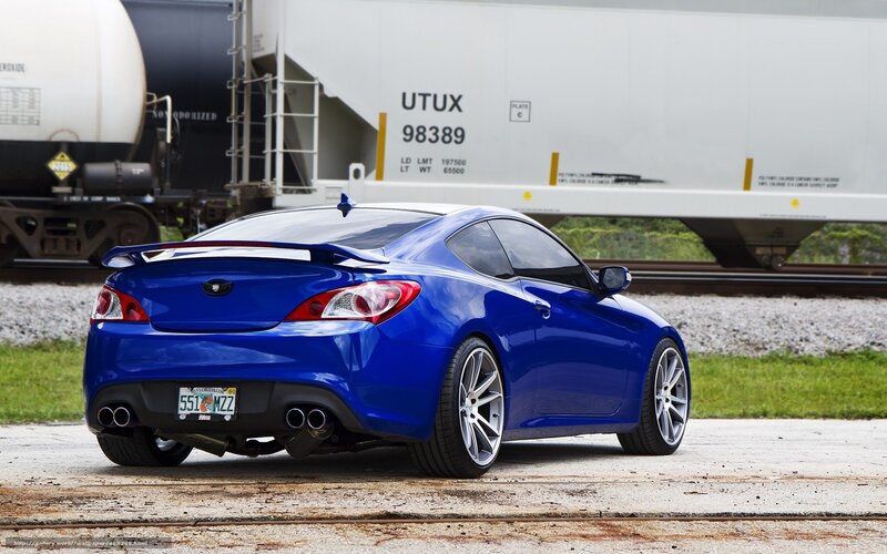Blue sports car near train tracks