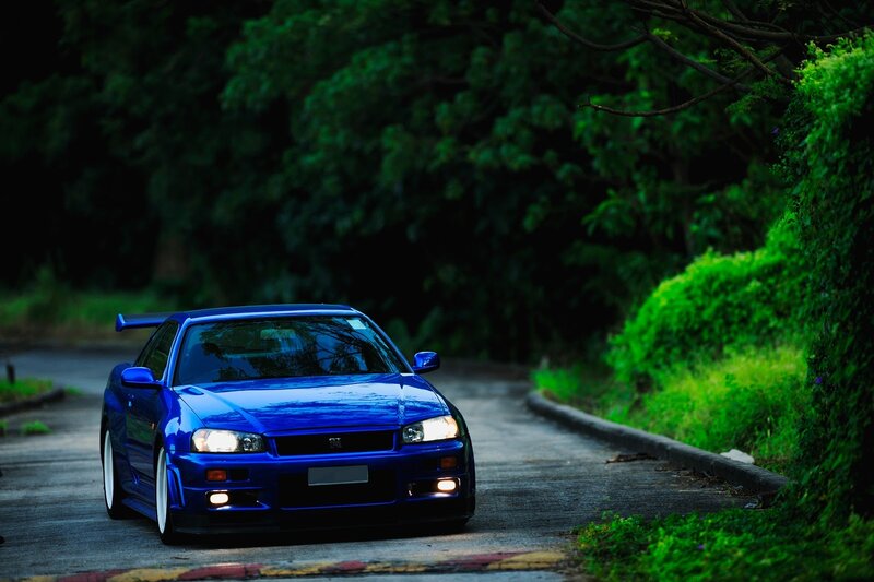 blue sports car on a forest road