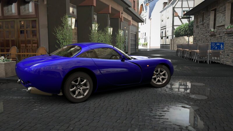 Blue sports car on cobblestone street