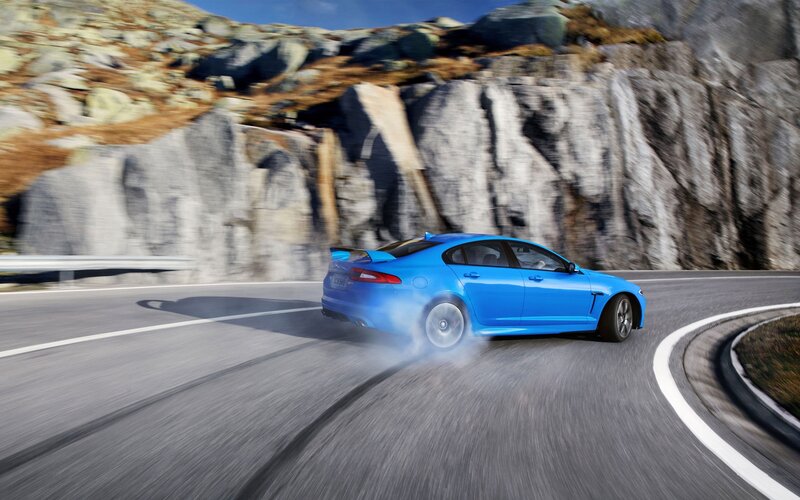 Blue sports car on mountain road