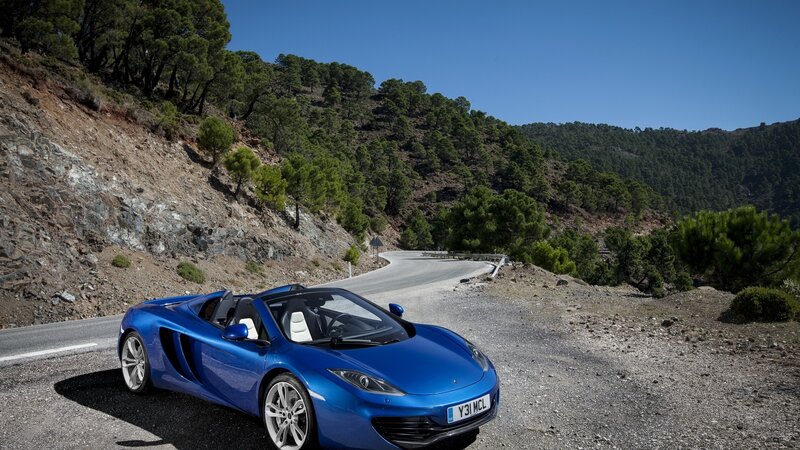 Blue sports car on mountain road