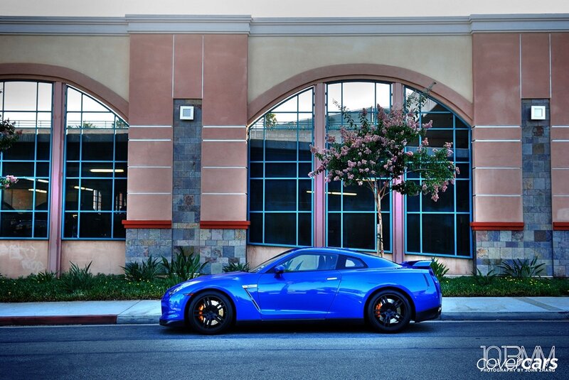 Blue sports car parked in front of building