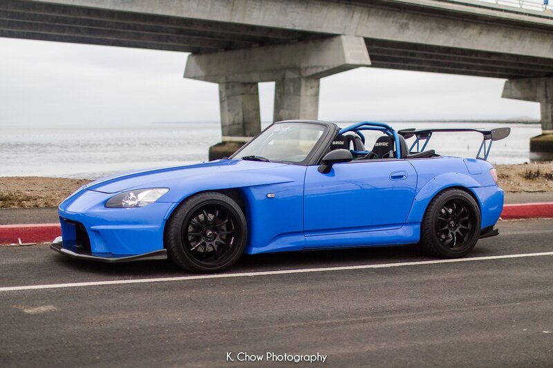 Blue sports car under a bridge