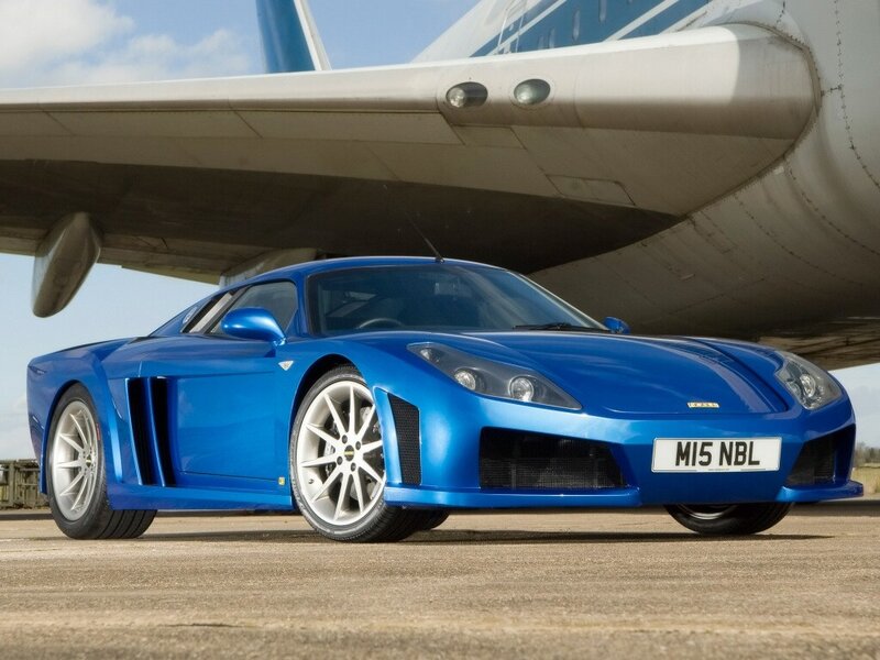 Blue sports car under airplane wing