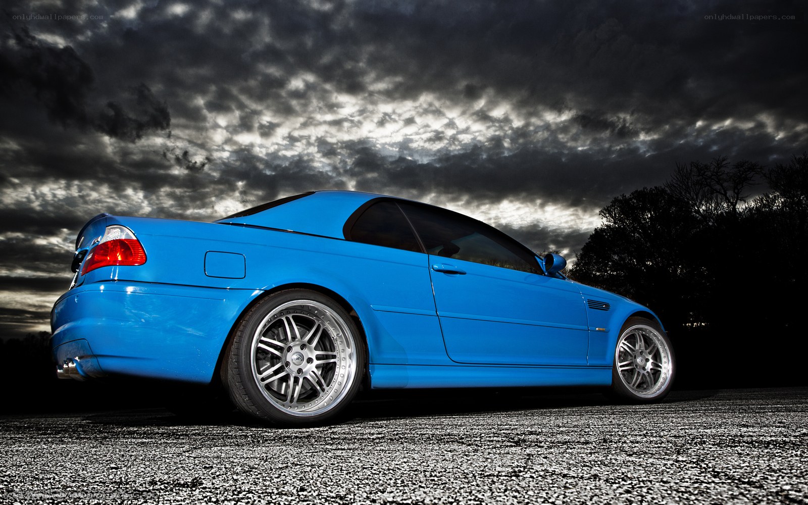 Blue sports car under stormy sky