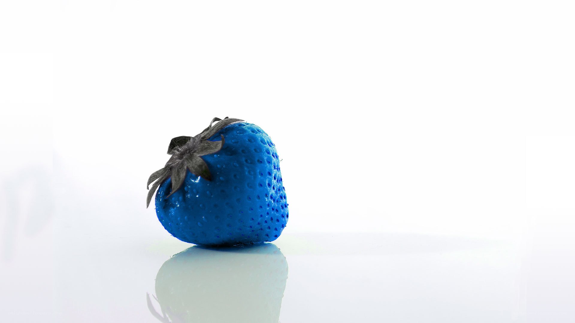 blue strawberry on white surface