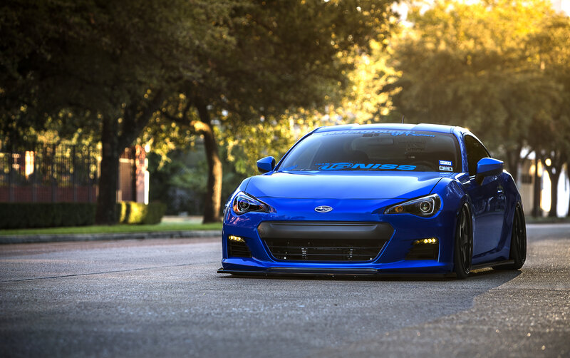 Blue Subaru BRZ on a tree-lined street