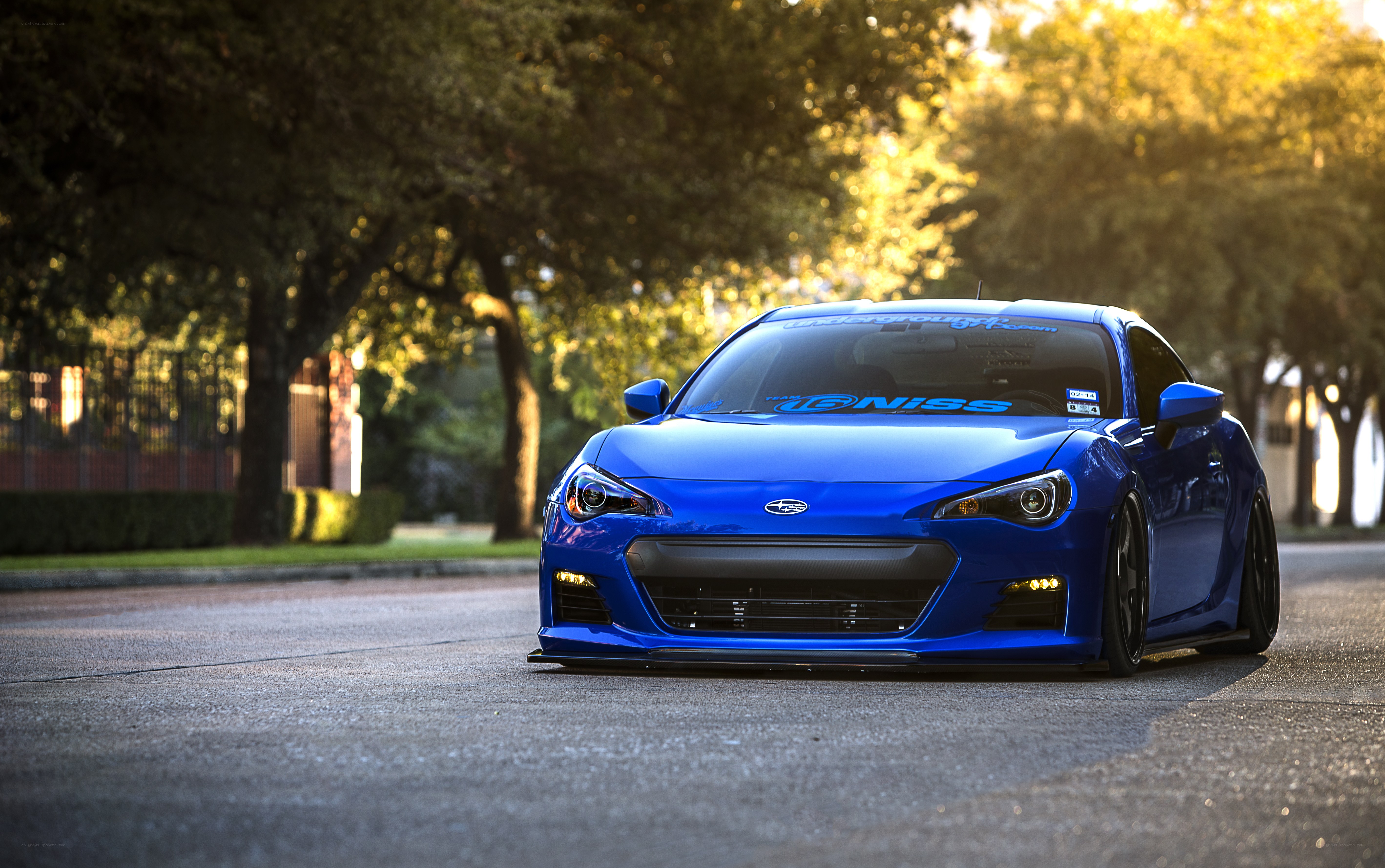 Blue Subaru BRZ on a tree-lined street