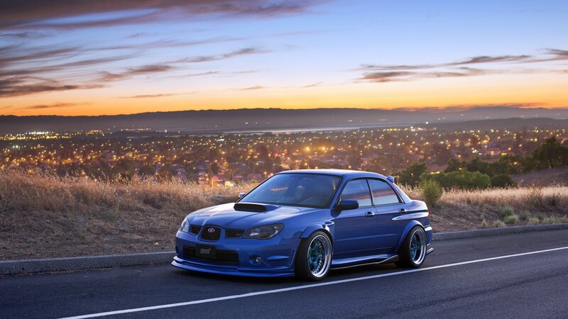 Blue Subaru on a hill at dusk