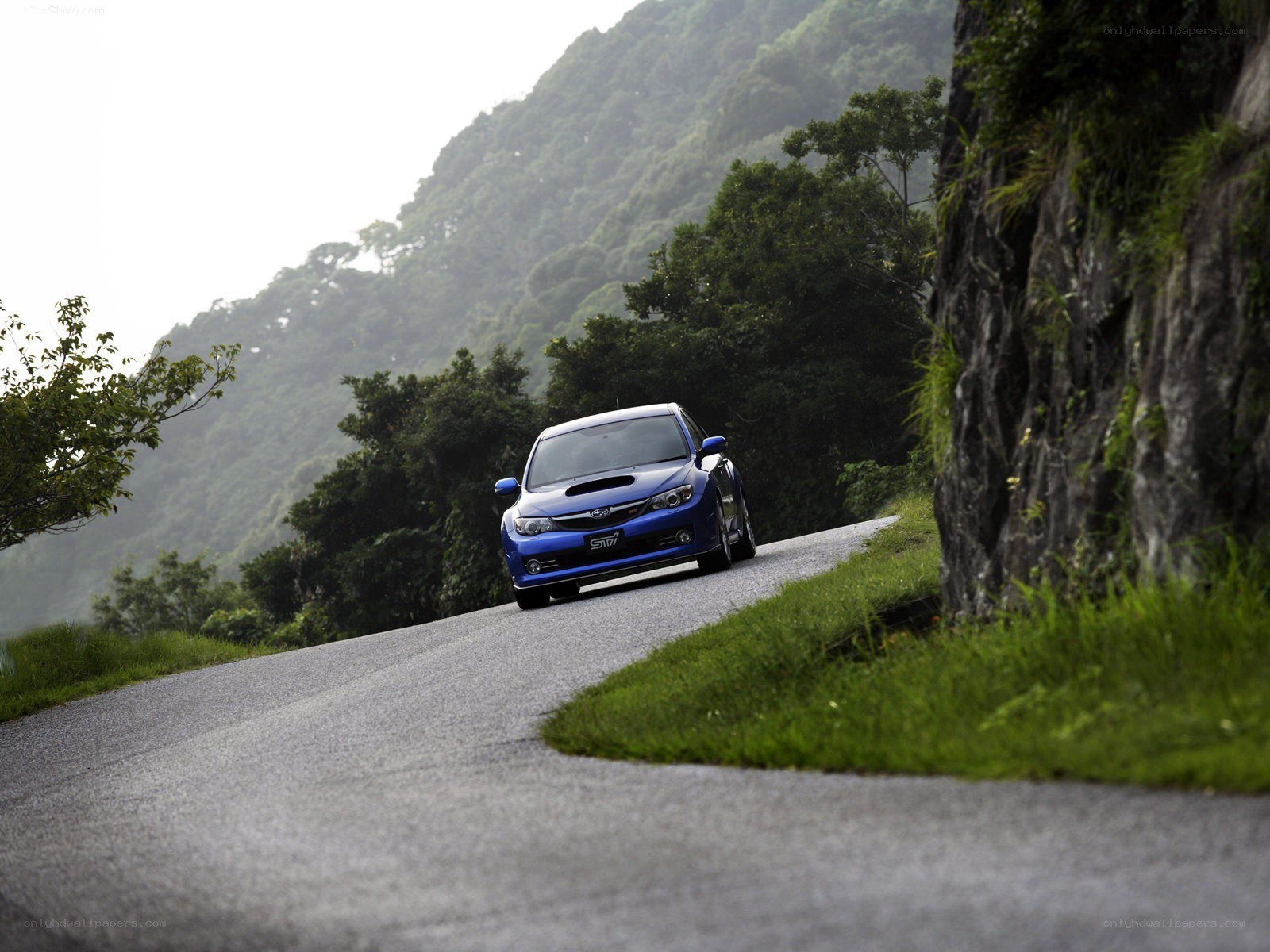 blue subaru on mountain road
