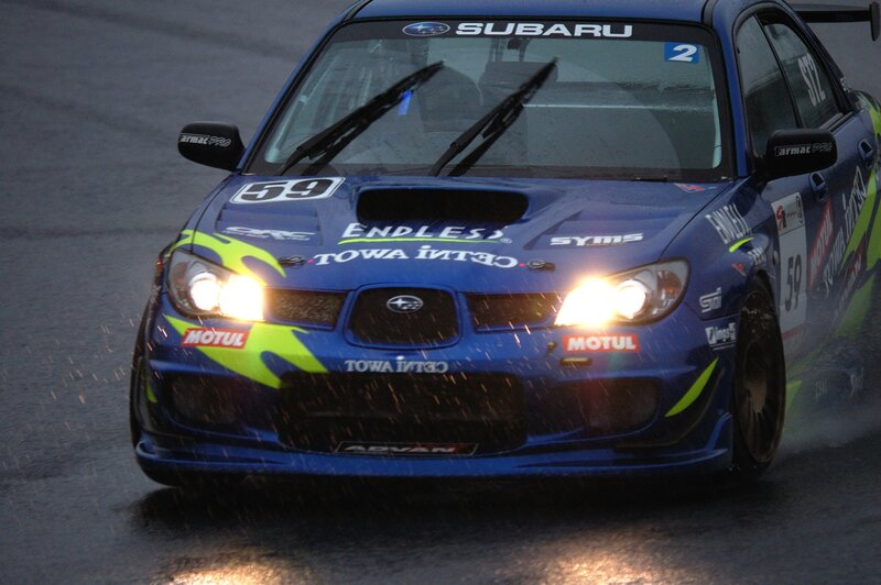 blue subaru race car on wet track
