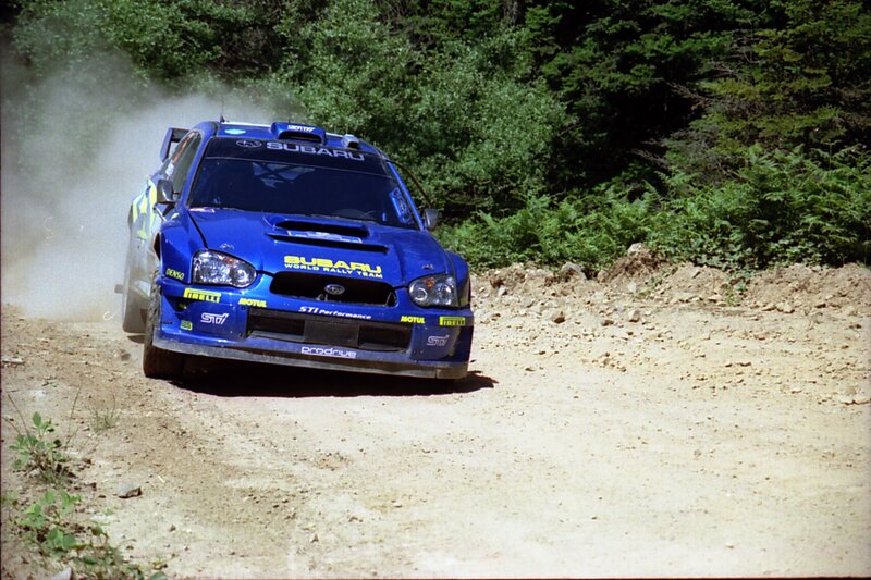 Blue Subaru rally car on dirt road