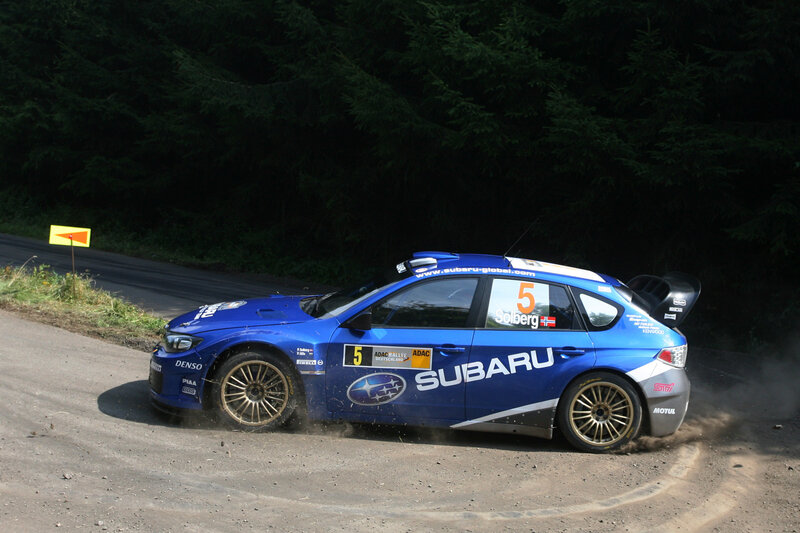 Blue Subaru rally car on dirt road