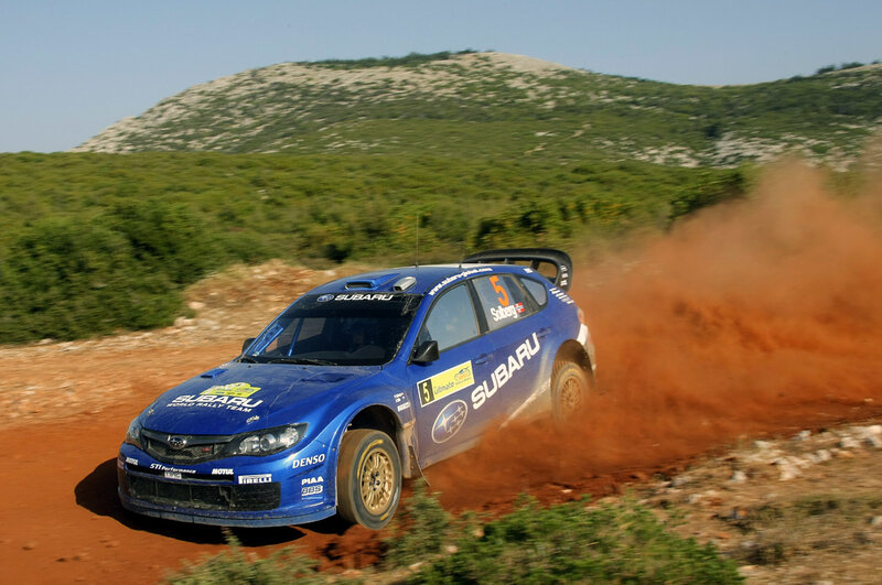 Blue Subaru rally car on dirt track