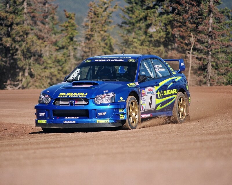 Blue Subaru rally car on dirt track